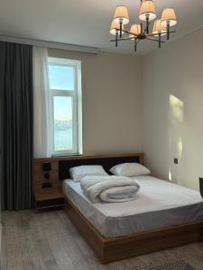 una camera da letto con un letto grande con una finestra di Studio Near Flag Square with Seaview a Baku