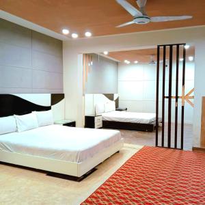 a bedroom with two beds and a red rug at Hospitality Hub in Islamabad +33 photos