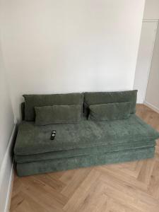 a green couch in the corner of a room at Opale - En plein coeur de la ville Dijon in Dijon