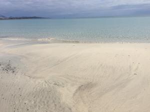 a sandy beach with the ocean in the background at HOTEL Al FARO , SPIAGGIA LA CINTA ,SAN TEODORO in San Teodoro