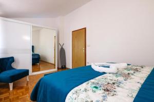 a bedroom with a blue bed and a mirror at Apartment Sunset Cove in Neum
