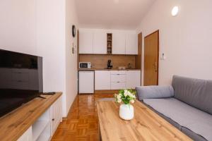a living room with a couch and a vase of flowers at Apartment Sunset Cove in Neum