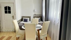 a dining room with a table and white chairs at Willa Ela in Gdańsk
