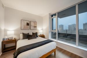Ένα ή περισσότερα κρεβάτια σε δωμάτιο στο Modern Lougheed Condo with Gym and Balcony near Skytrain