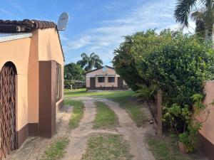 a dirt road in front of a house at Hlalanathi Lodges - 25 North Drive Margate in Margate