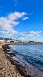 a beach with water and buildings in the background at The Blue Loft in Anstruther +46 photos