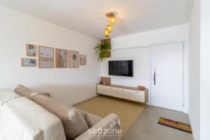 ein Wohnzimmer mit Sofa und Fernseher in der Unterkunft Apto Novo a 150m da Praia de Pereque CLE1202 in Perequê