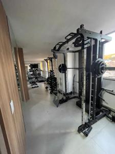 a gym with rows of equipment in a room at Absolut Residense in João Monlevade