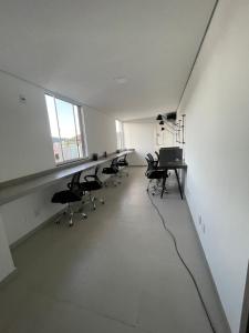 an empty room with chairs and a desk in it at Absolut Residense in João Monlevade