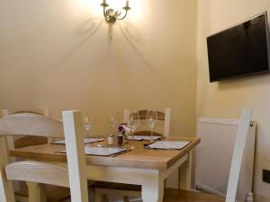 mesa de comedor con copas de vino y TV en Fferam Gorniog, en Holyhead