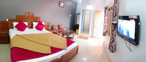 una camera con letto e TV a schermo piatto di Tn27callingkrishholiday a Yercaud