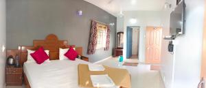 una camera da letto con un letto grande con cuscini rossi di Tn27callingkrishholiday a Yercaud
