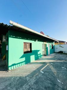 a green building with a window in a parking lot at Pousada Palmeiras in Santo Amaro +23 photos