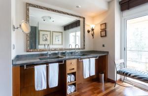 a bathroom with a sink and a large mirror at Suites del Mar Fenals Apartments in Lloret de Mar