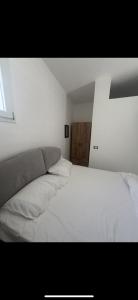 フォリオ・ディスキアにあるP&P Apartmentの白いベッドと窓のある寝室