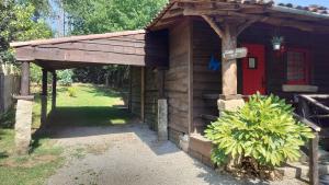 a small wooden cabin with a red door at T2 Bungalow in Estorãos