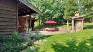 un patio con una mesa y una sombrilla junto a una casa en T2 Bungalow, en Estorãos