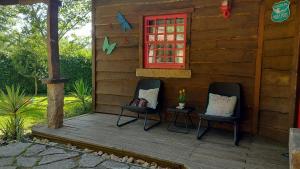 dos sillas sentadas en el porche de una cabaña en T2 Bungalow, en Estorãos