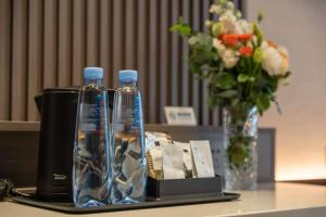 青岛沃德酒店青岛石老人海水浴场国际会展中心店的桌子上有两瓶水和一瓶花