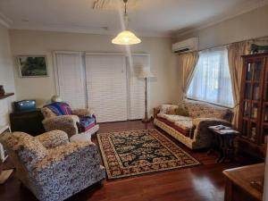 un soggiorno con due sedie e un divano di Albert Road Cottage - late art deco 3 bedroom house and caravan a Bunbury