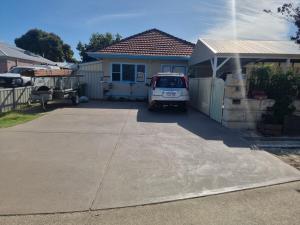 un furgone parcheggiato di fronte a una casa. di Albert Road Cottage - late art deco 3 bedroom house and caravan a Bunbury