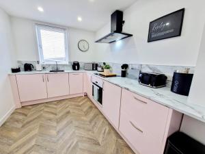 a kitchen with white cabinets and a counter top at Koselig Properties in Lerwick