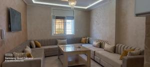 a living room with a couch and a table at Appartement quartier marsa al hoceima 1 in Al Hoceïma