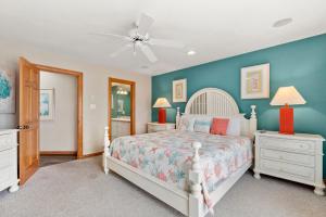 a bedroom with a white bed and blue walls at White Dolphin Left in Corolla +41 photos