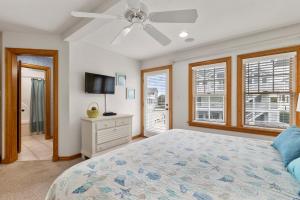 a bedroom with a bed and a ceiling fan at White Dolphin Left in Corolla