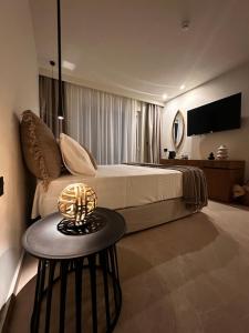 a bedroom with a bed and a table with a lamp at Rhotheon Suites in Ialysos Rhodes - private pool in selected rooms in Ialysos