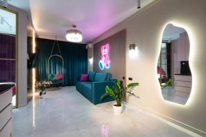 アルマトイにあるLa Talle apart hotelのリビングルーム(青いソファ、ネオンサイン付)