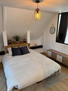ein Schlafzimmer mit einem großen weißen Bett und einem Fenster in der Unterkunft L'écrin ardéchois - Calme, forêt, lac privé in Saint-Agrève + 22 Fotos