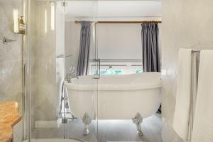 a white bathroom with a tub and a sink at Hotel Bardot Boutique in Panama City