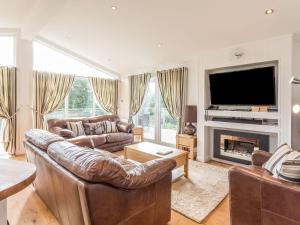 a living room with two leather couches and a television at 2 Tree Tops in Looe