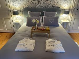 a bed with two towels and a tray of food on it at Château Maranne in Parthenay +14 photos