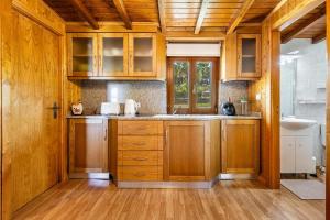 a kitchen with wooden cabinets and a sink at Chalets do Toleiro in Selhariz
