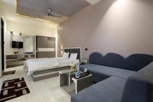 una habitación de hotel con una cama y un sofá en Hotel KV Pride, en Mehekar