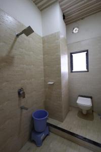 baño con ducha, aseo y ventana en Hotel KV Pride, en Mehekar 6 fotos más