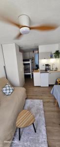 sala de estar con ventilador de techo y cocina en Charmant studio à la mer, en Narbona