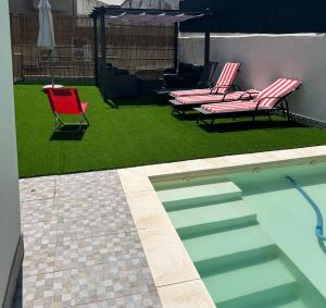 einen Garten mit zwei Stühlen und einem Pool in der Unterkunft Vivenda Branca Martinho II in Peso da Régua