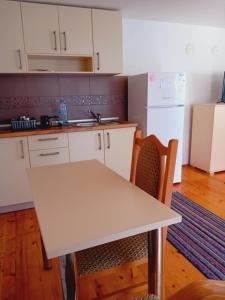 a kitchen with a white table and a white refrigerator at Apartman vo Struga in Struga