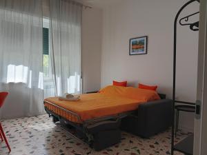 サレルノにあるNonna Ida homeのベッドルーム1室(オレンジ色の掛け布団、窓付)