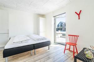 Un dormitorio con una cama y una silla roja. en 907-Hvide-Sande-Langsand-108, en Hvide Sande