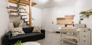 a living room with a black couch and a kitchen at DUPLEX DU GET in Revel