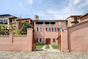 a pink house with a gate in front of it at Casa Viberti, Dimora storica con vista mozzafiato sulle Langhe in Serralunga d'Alba