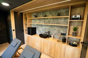 een badkamer met twee blauwe stoelen en een stenen muur bij Brioni Hills - Premium Escape in Šmarje pri Jelšah +19 foto's