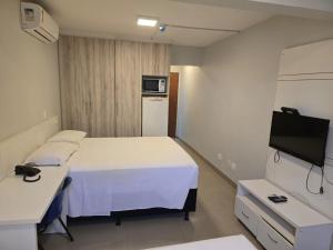 a hospital room with a bed and a tv at Apartamento econômico Garvey Hotel in Brasilia