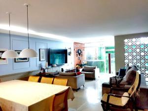 a living room with a couch and a table and chairs at Casa Modernista - Aluguel de Suítes in Brasilia