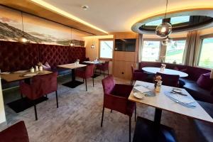 jadalnia ze stołami i czerwonymi krzesłami w obiekcie Haus Tirol w mieście Tux