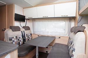 a dining room and kitchen in a tiny caravan at Encar - Bliżej nie będzie in Zator